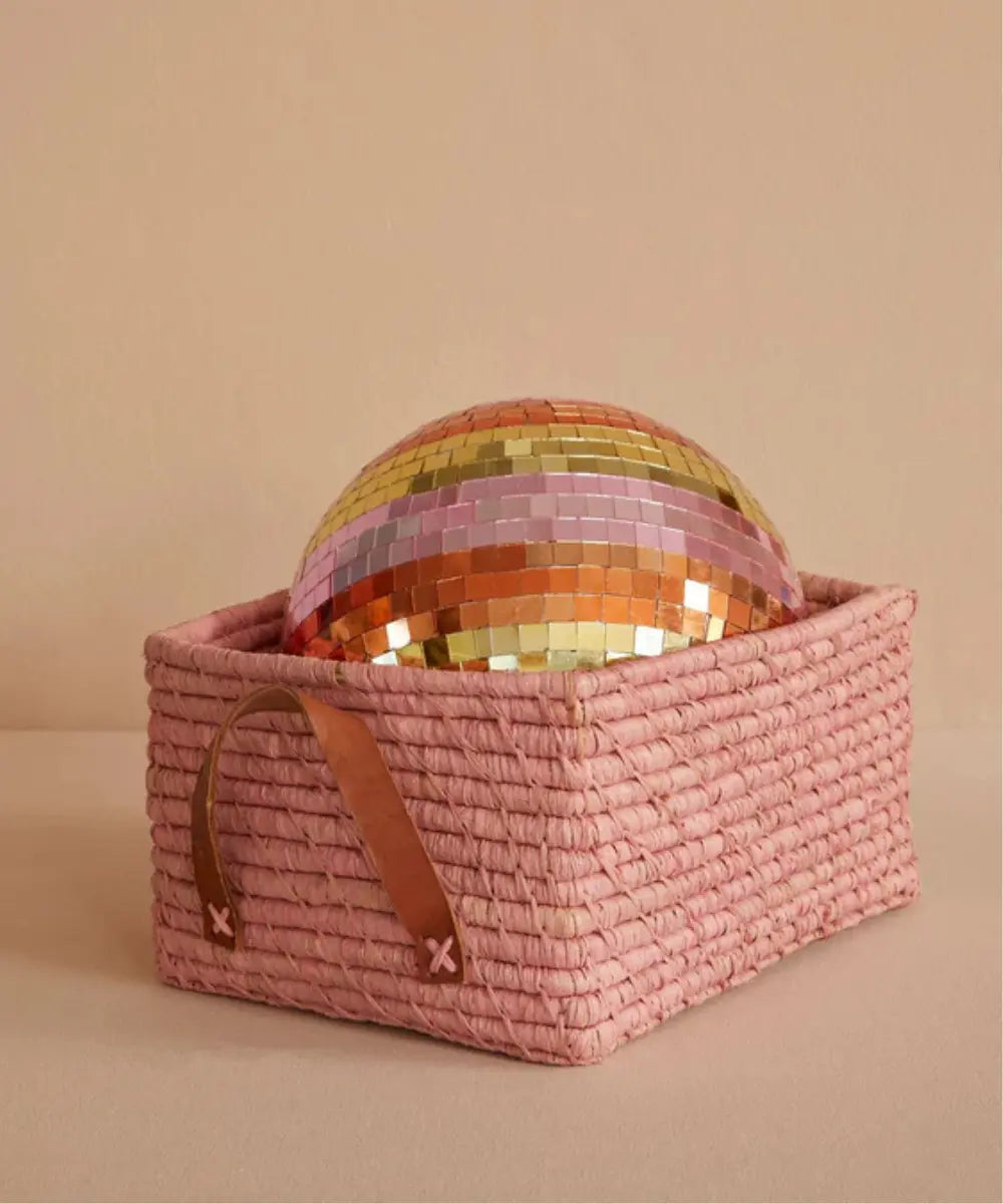 Grande boule disco multicolore avec facettes de miroirs colorés réalisée par la marque Rice, posée dans un panier