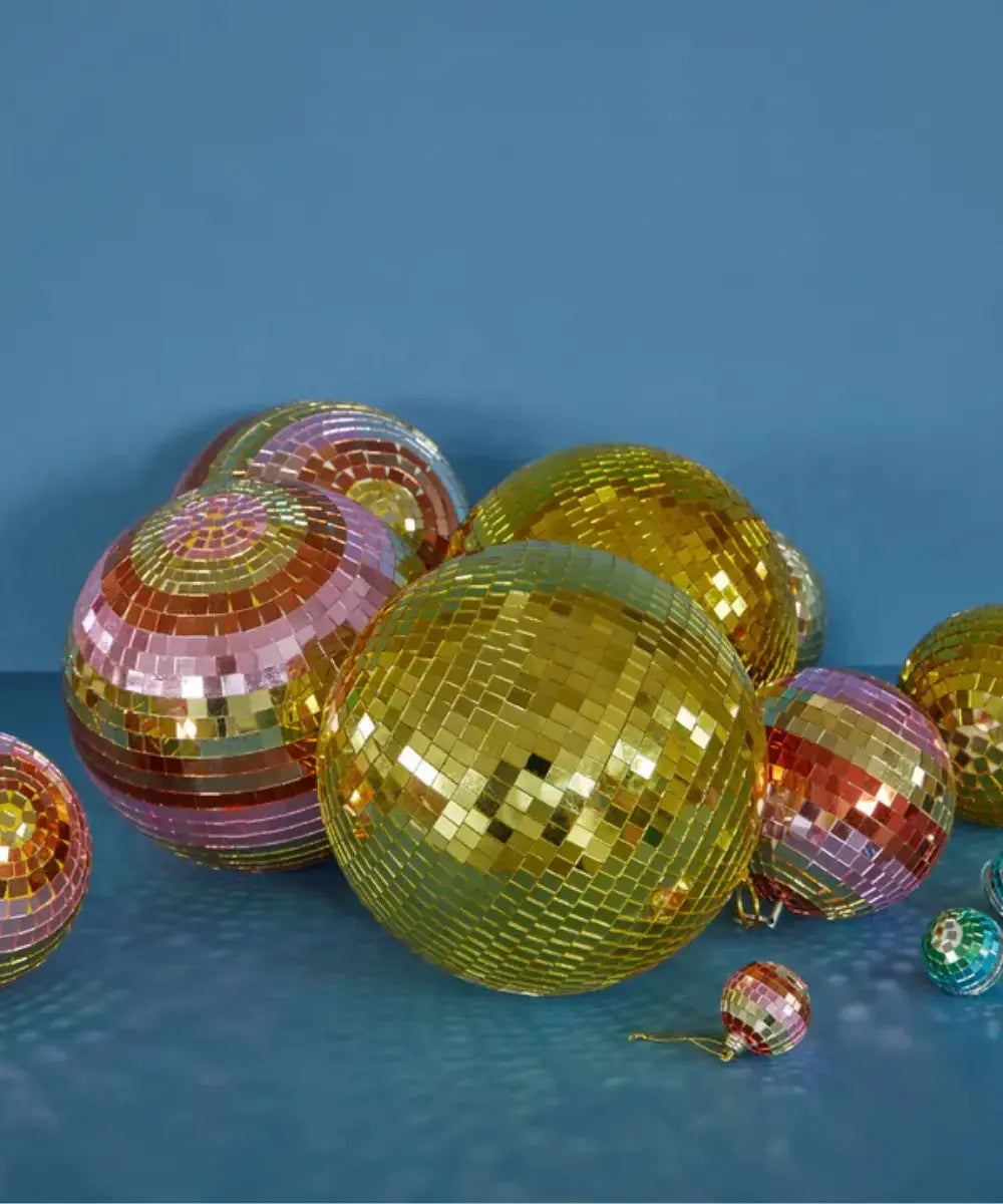 Grande boule disco multicolore avec facettes de miroirs colorés réalisée par la marque Rice posée sur le sol