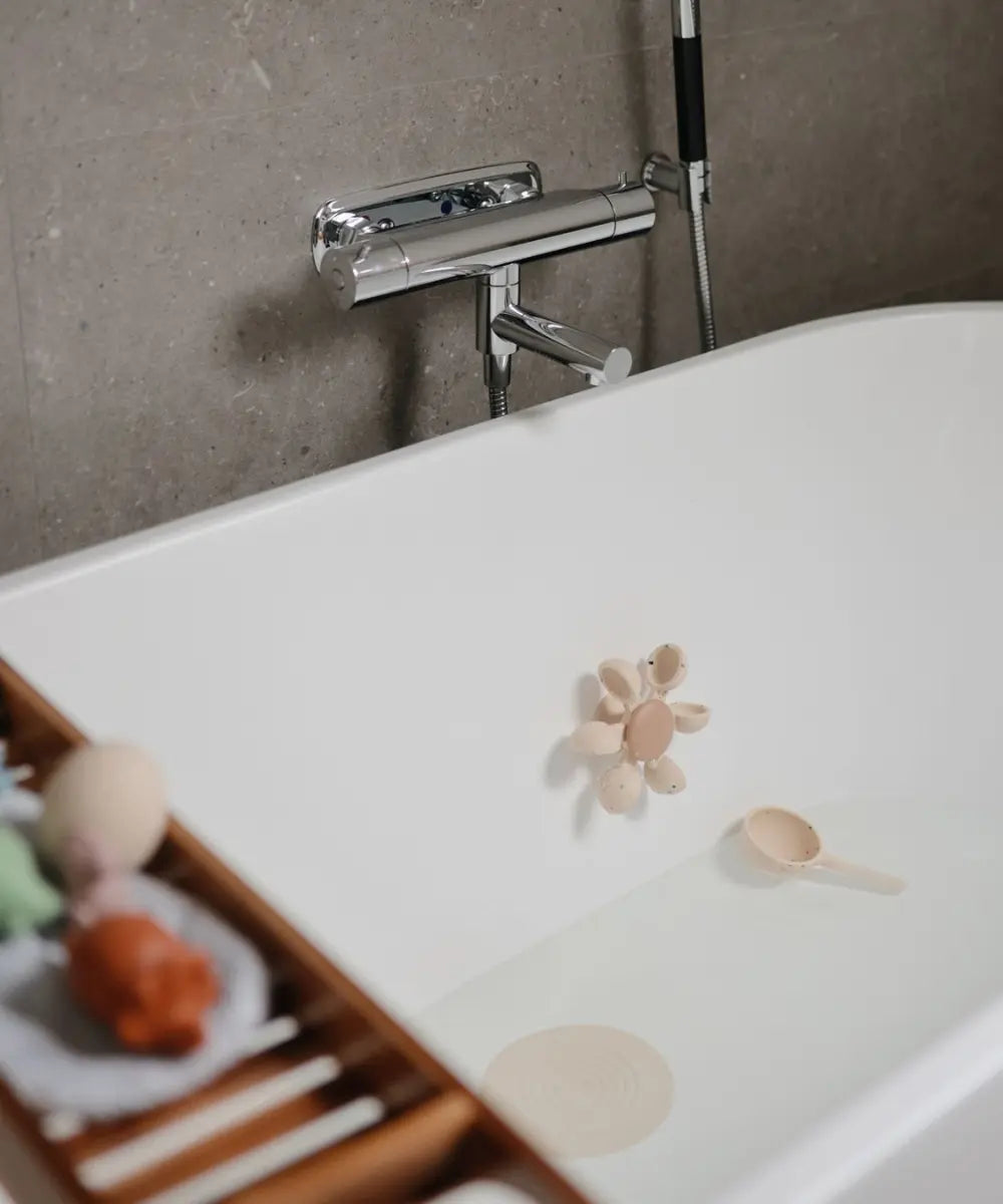 Jouet de bain Mushie fixée sur la paroi d'une baignoire