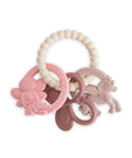 Anneau de dentition en silicone rose poudré avec formes de licorne et papillon Mushie.