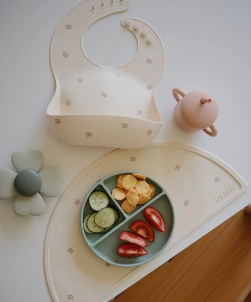 Jouet d'éveil pour bébé spinner ventouse Lucky de la marque Mushie fixé sur une table
