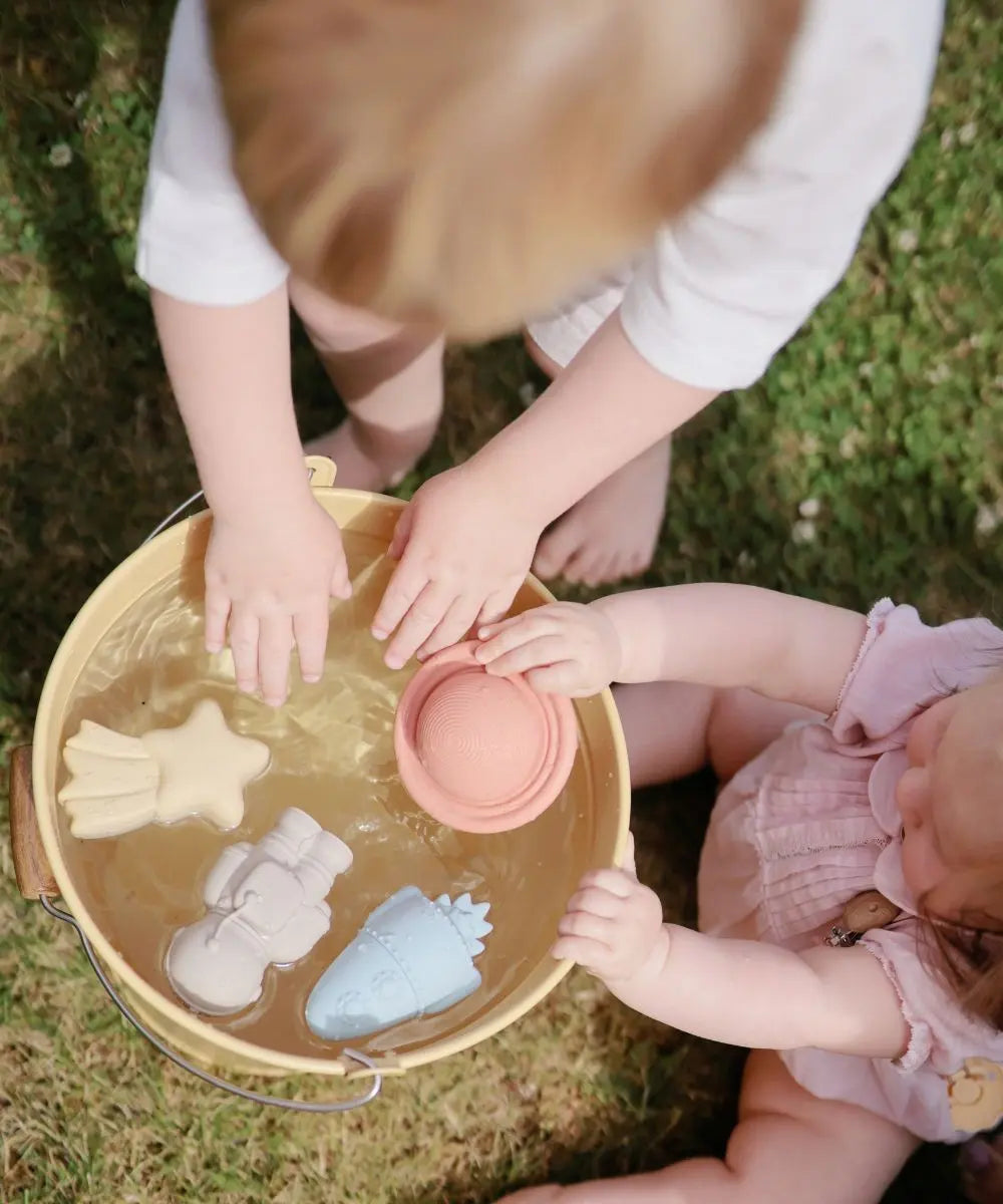 Enfants en train de jouer avec les Jouets pour le bain en silicone Espace de la marque Mushie
