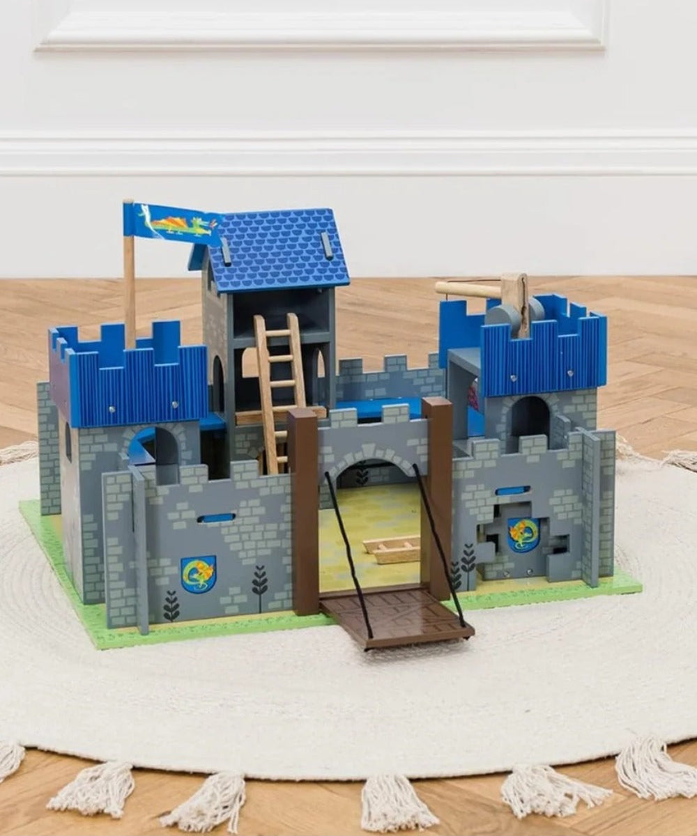 Château fort Excalibur Le Toy Van posé sur un tapis dans une chambre, pont-levis abaissé