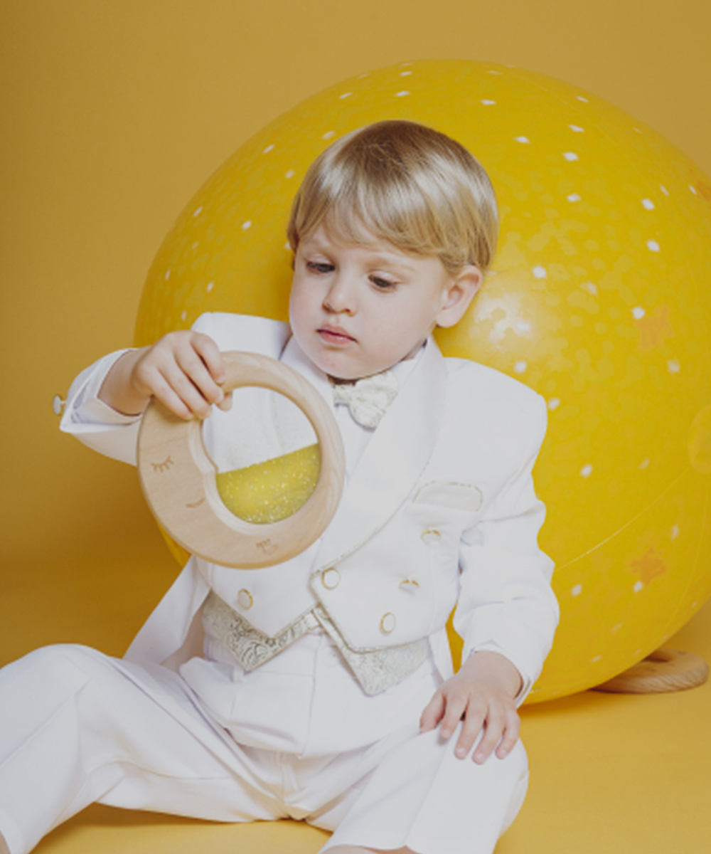 Jouet d'éveil Lune sensorielle en bois avec paillettes jaune de la marque Petit Boum utilisé par un enfant de 18 mois