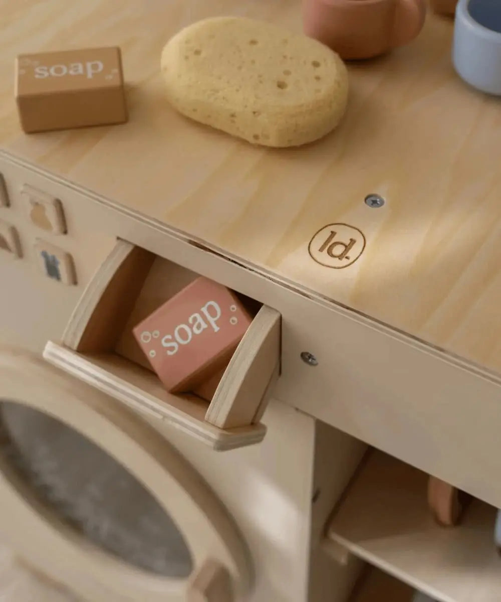 Détail du lavabo, de l'égouttoir et des accessoires en bois (tasses et savon).