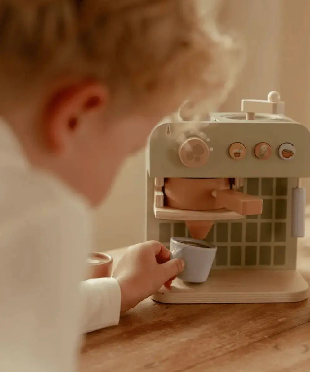 Enfant de deux ans en train de jouer avec la machine à café Little Dutch