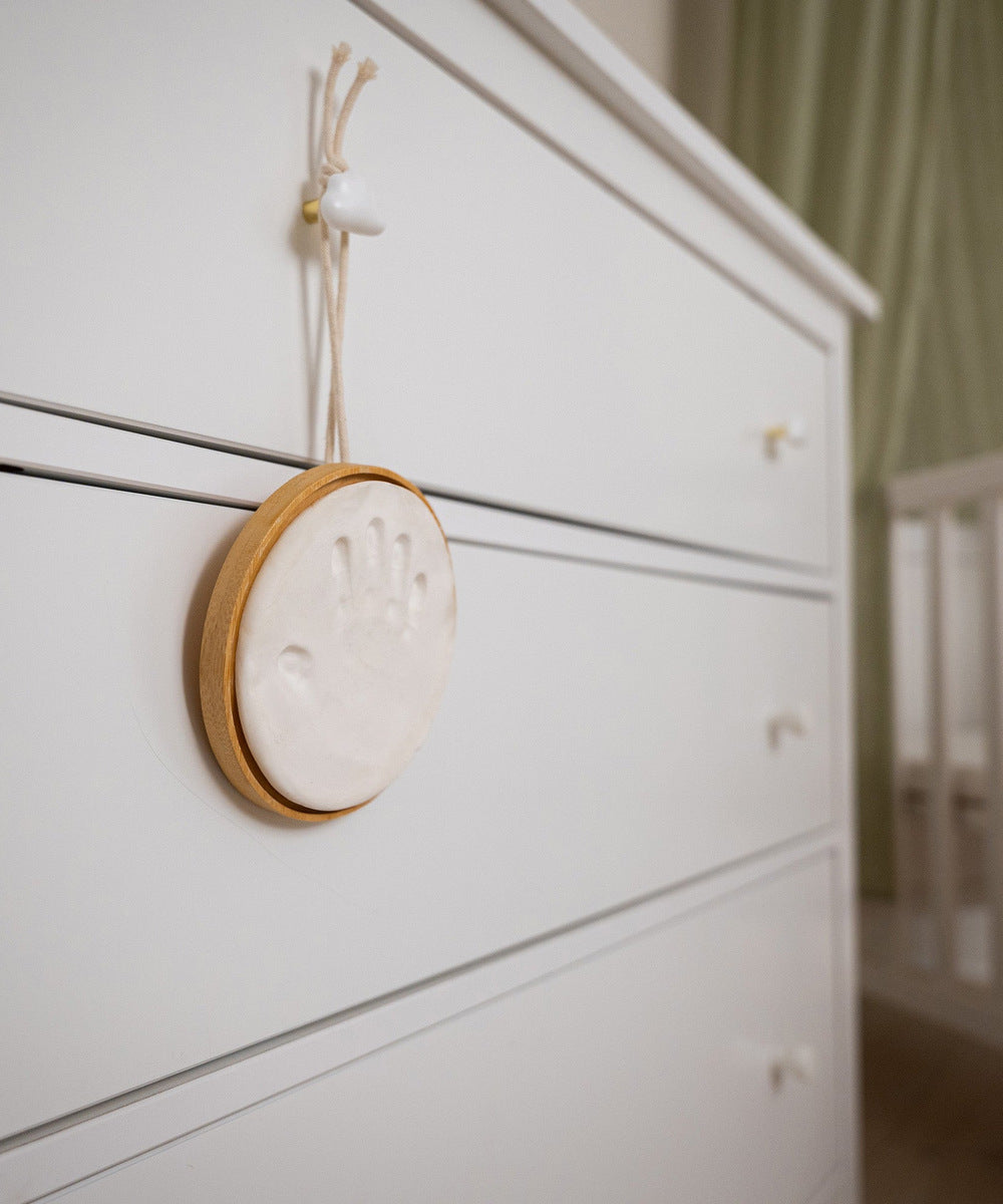 Médaillon empreinte bois accroché à un meuble de chambre