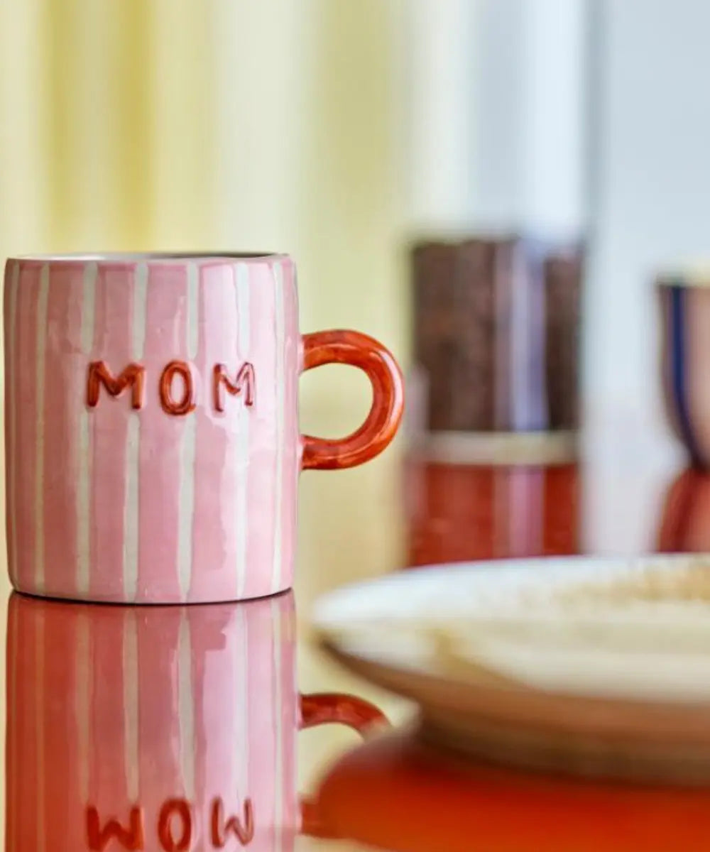 Mug en grès Mom Cherish de la marque de décoration Bloomingville posé sur une table