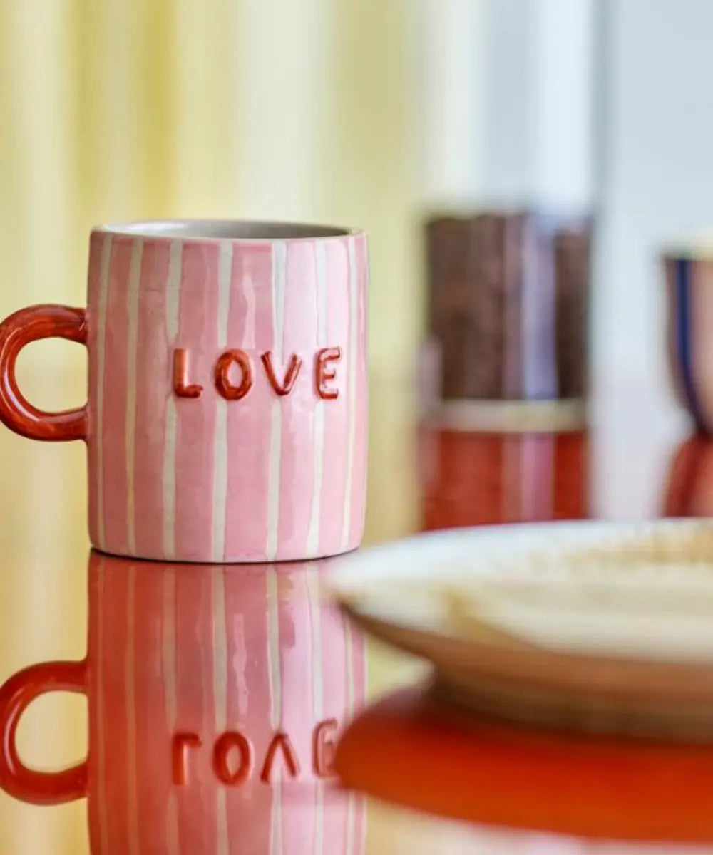 Mug en grès Mom Cherish de la marque de décoration Bloomingville posé sur une table