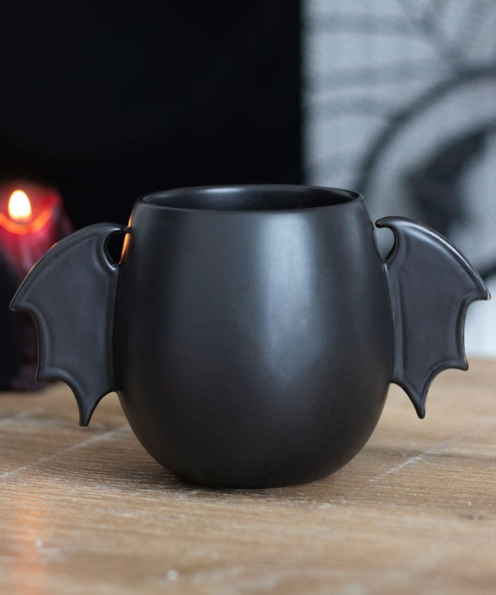 Mug noir ailes de chauve-souris de la marque Something Different, présenté dans une ambiance d'Halloween