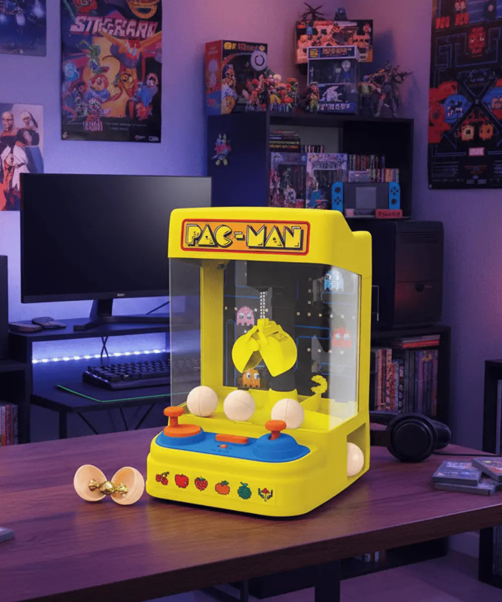 Borne d'arcade Machine a pince Pac-Man posé sur une table dans la chambre d'un geek