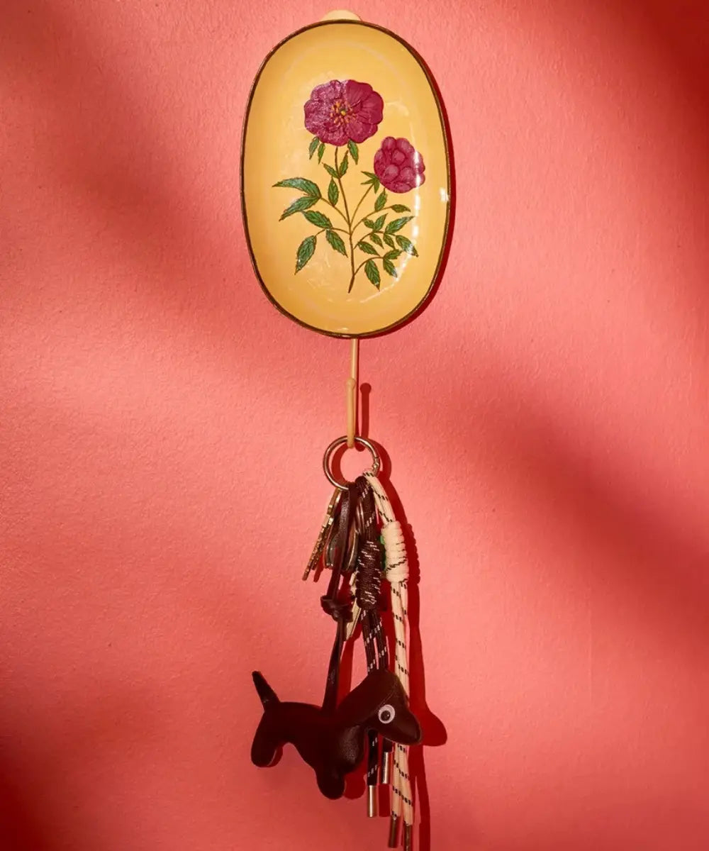 Patère en métal émaillé Fleurs de la marque danoise Rice installée sur un mur rose