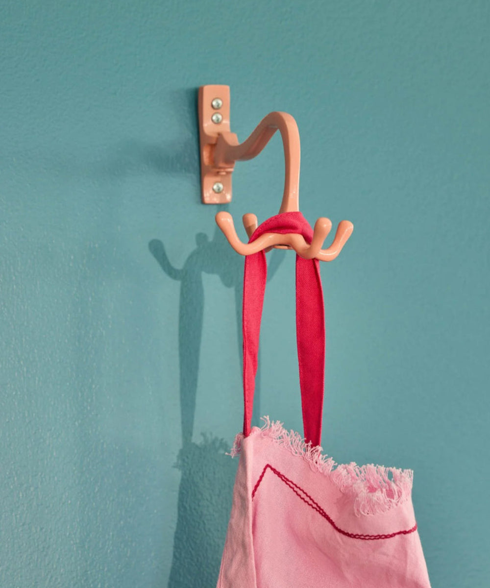Patère murale rotative en métal rose de la marque danoise Rice, parfait pour torchons et sacs.