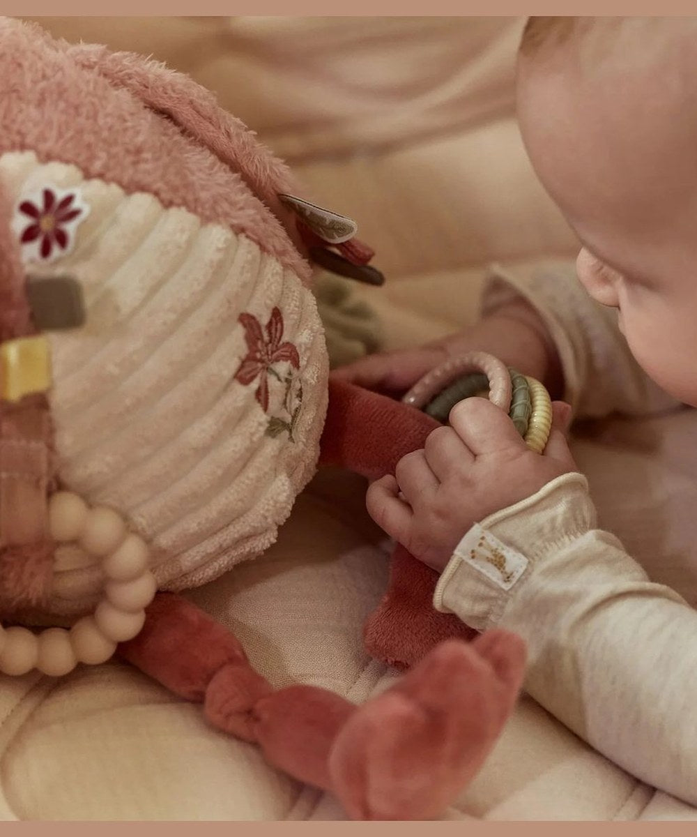 Détail des anneaux et des tissus de la peluche Flamant rose près de bébé