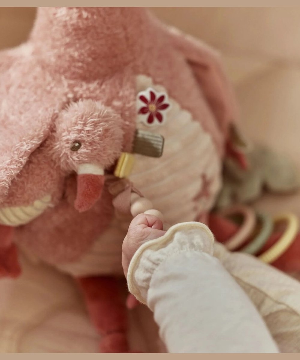 Bébé explore le petit détail suspendu à la peluche Flamant rose Little Dutch