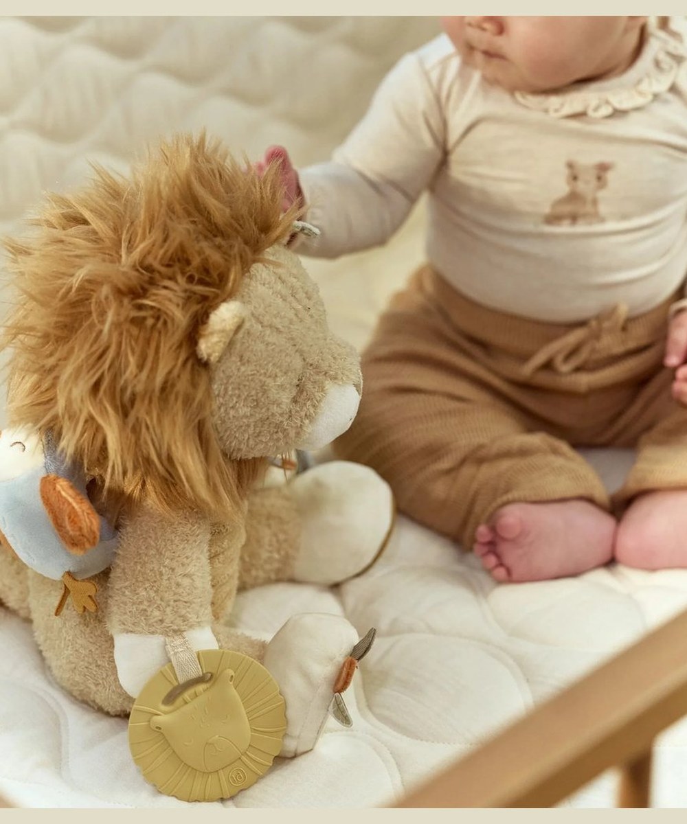 Peluche d'activités Lion Little Dutch posée près d'un bébé
