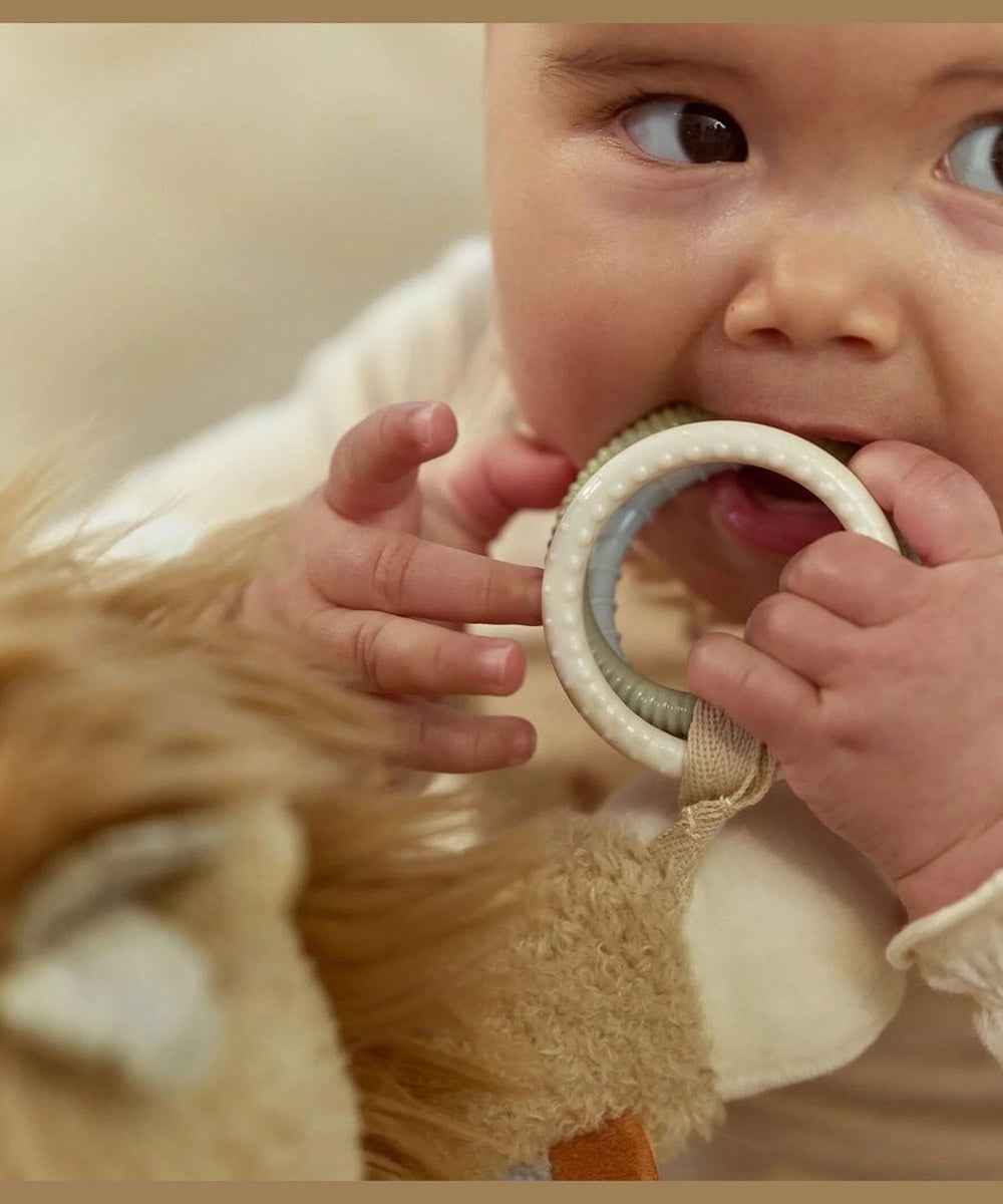 Bébé explore l'anneau de dentition de la peluche Lion Little Dutch