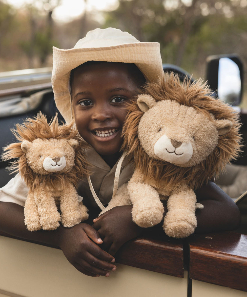 Enfant avec deux tailles de peluches lion Safari Friends ; peluches vendues séparément