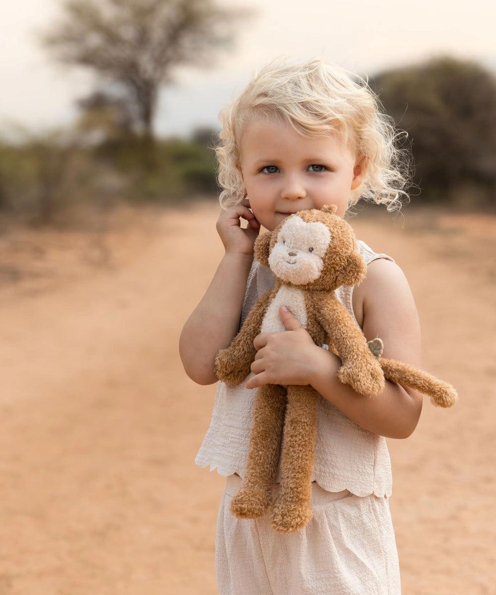 Enfant tenant la peluche singe Safari Friends dans les bras