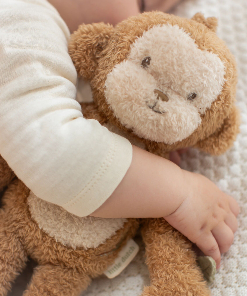 Enfant câlinant une peluche singe Safari Friends