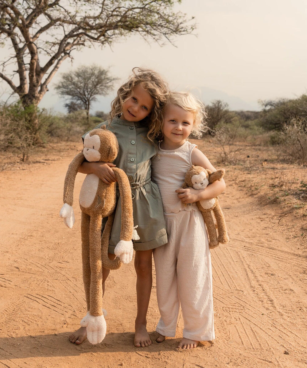 Deux enfants avec des peluches singe Safari Friends de tailles différentes ; autres tailles vendues séparément