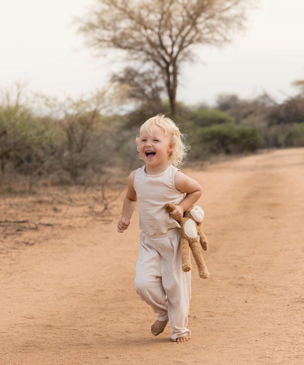 Enfant courant avec une peluche singe Safari Friends
