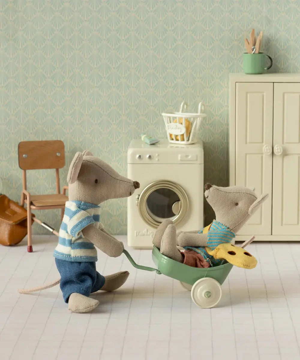 Poupée petit frère souris Maileg avec son petit sac mis en scène dans une maison de poupées