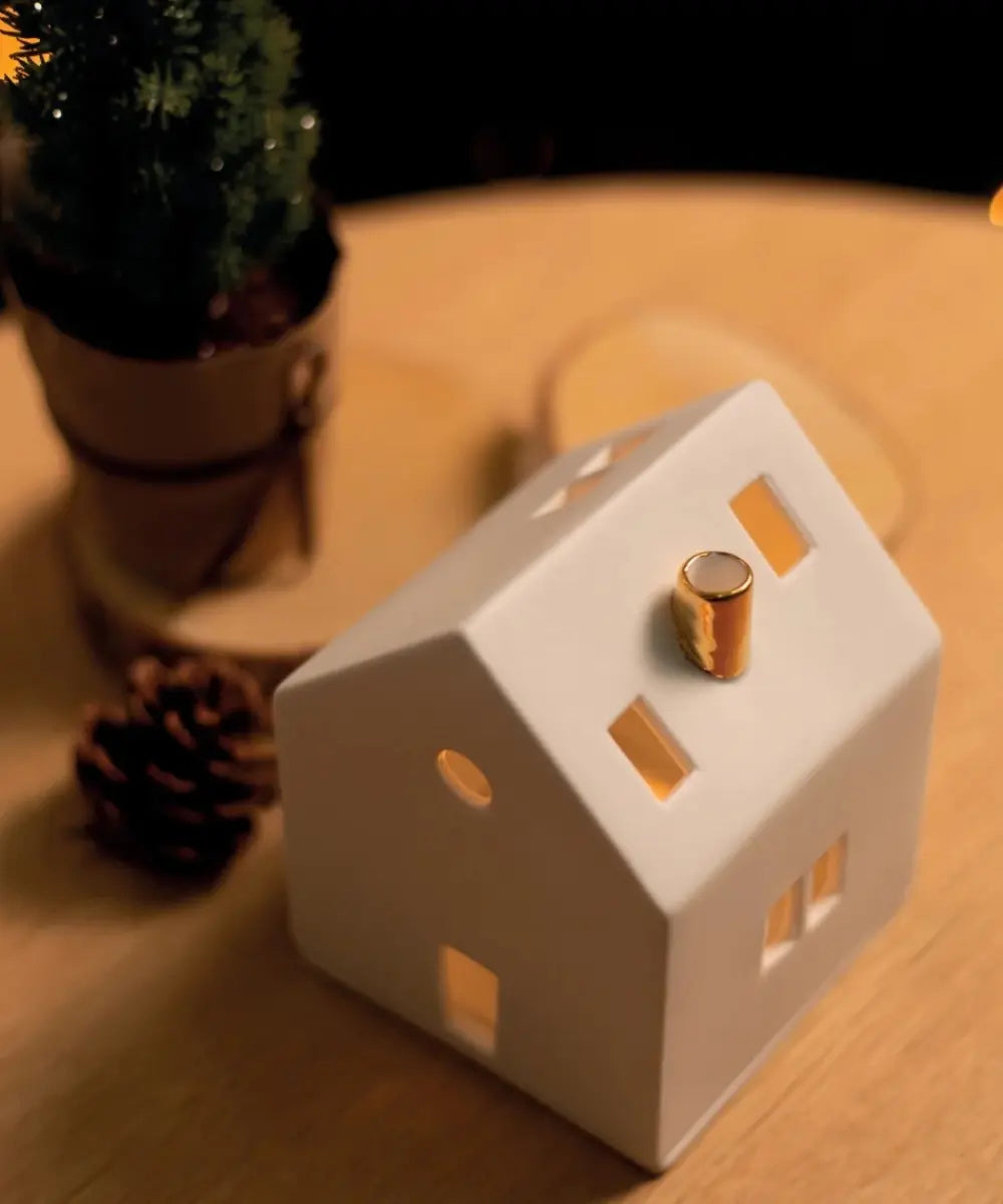 Photophore maison en porcelaine blanche Räder avec cheminée dorée et fenetres decoupées.