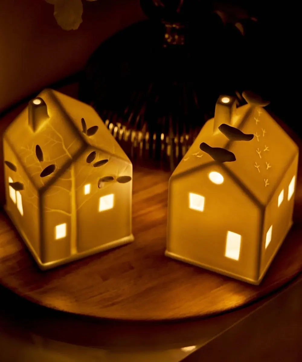 Photophore maison en porcelaine blanche de la marque Räder avec petits oiseaux perchés sur le toit.