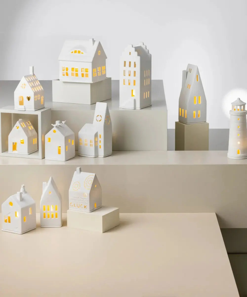 Photophore maison en porcelaine blanche de la marque Räder avec petits oiseaux perchés sur le toit.