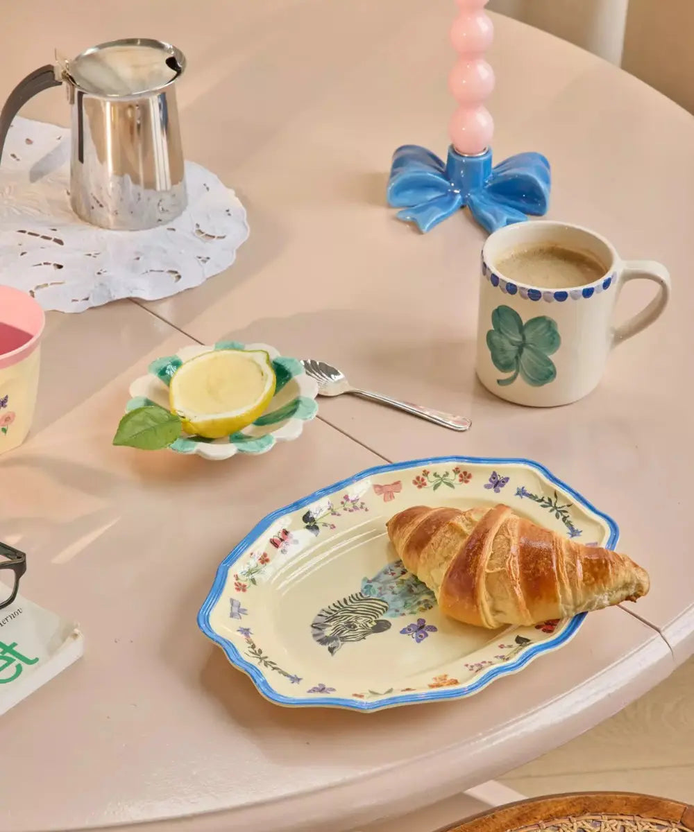 Petit plat en mélamine Zèbre de la collaboration entre Nathalie Lété et la marque danoise Rice, posé sur une table colorée