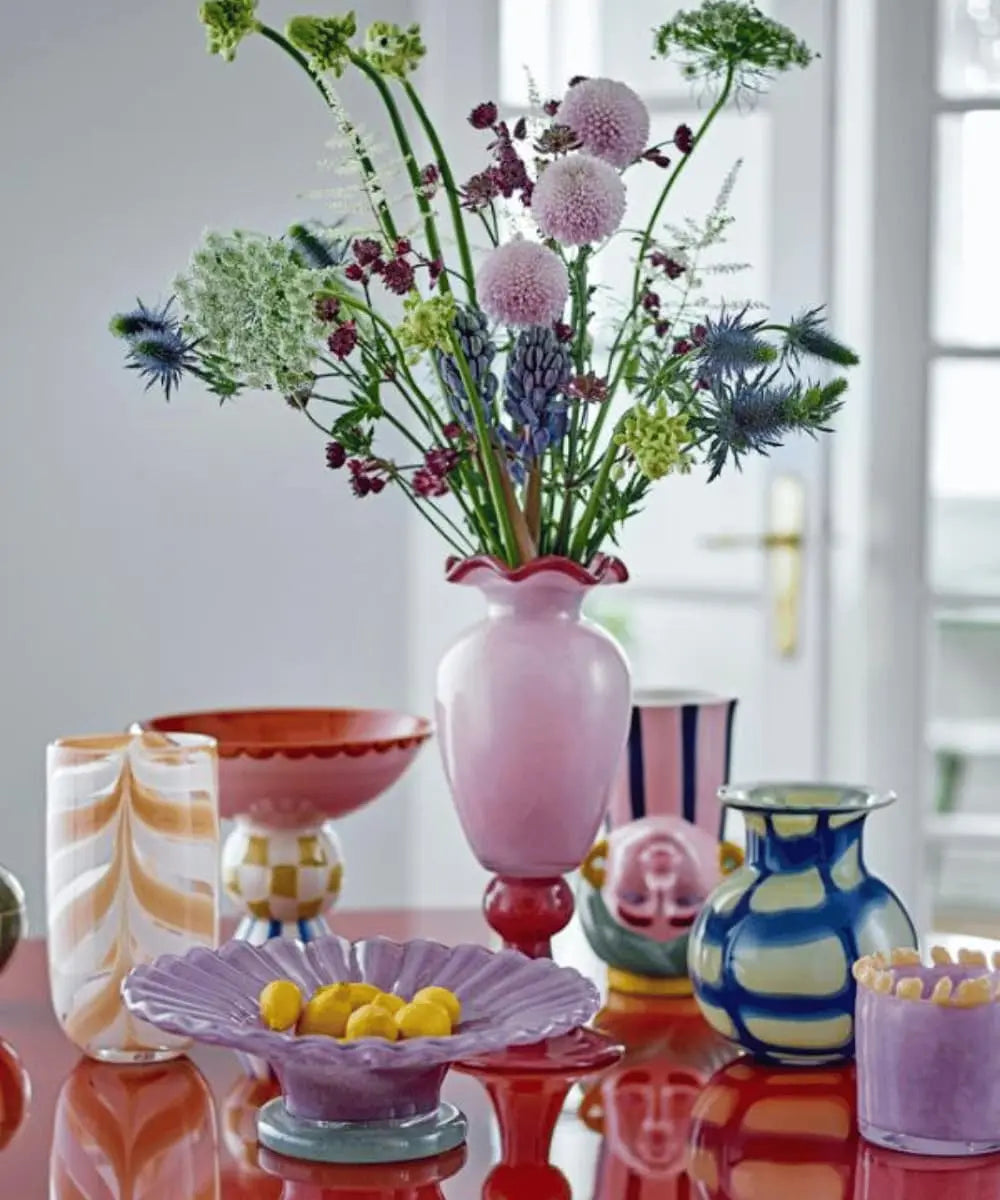 Plat sur pied Bob posé sur une table colorée