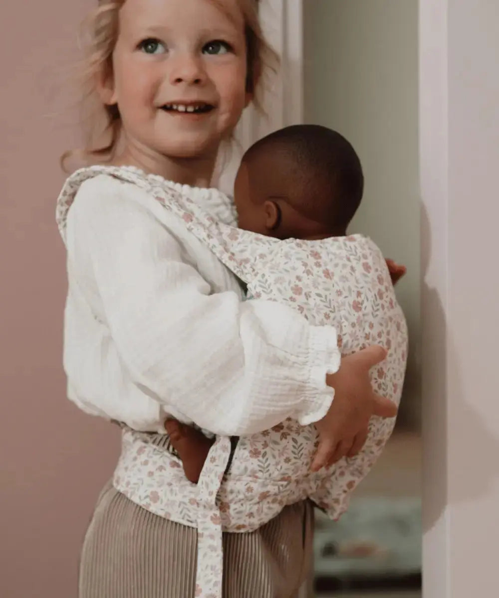Enfant portant une poupée dans le porte-bébé de Little Dutch