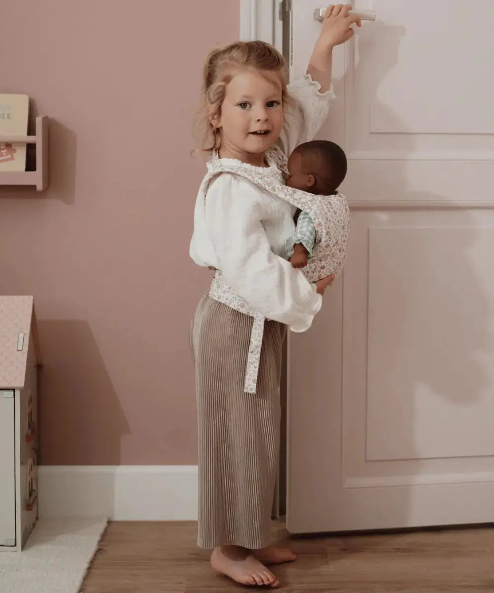 Enfant de 3 ans portant une poupée dans le porte-bébé de Little Dutch