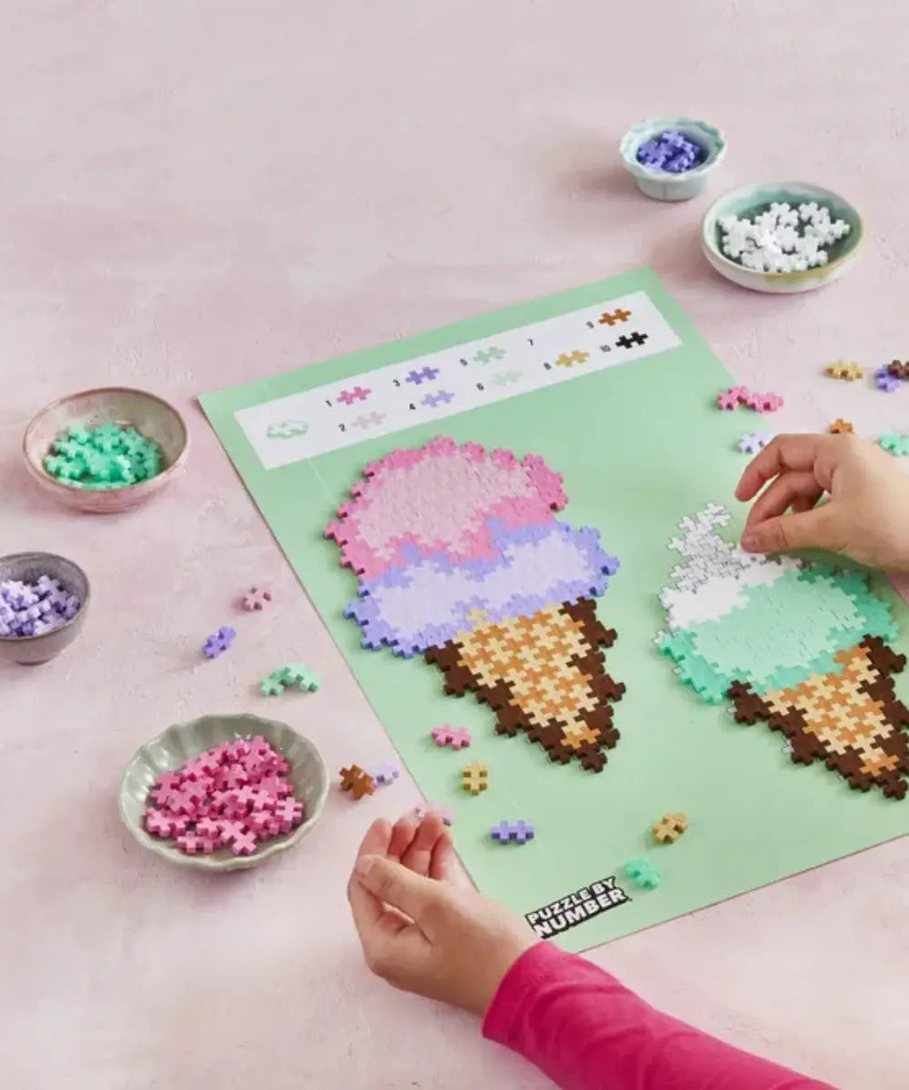 Enfant en train de réaliser le Puzzle by Number Cornet de Glaces de la marque Plus Plus