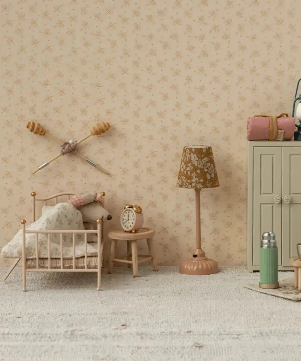 Réveil rose Maileg posé sur une table de chevet miniature dans une maison de souris.