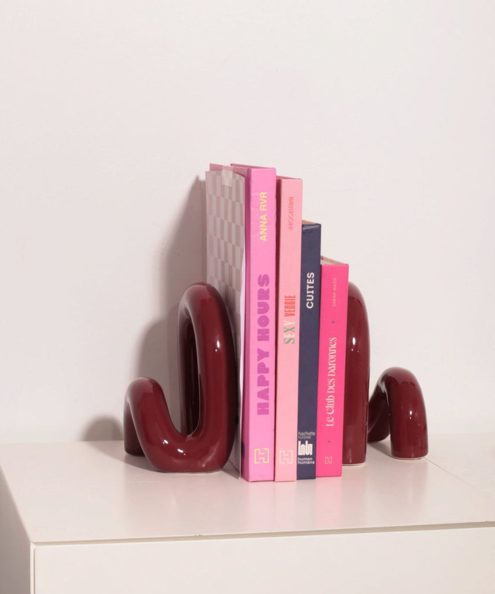 Serre-livres Cowboy bordeaux installés sur une étagère avec des livres