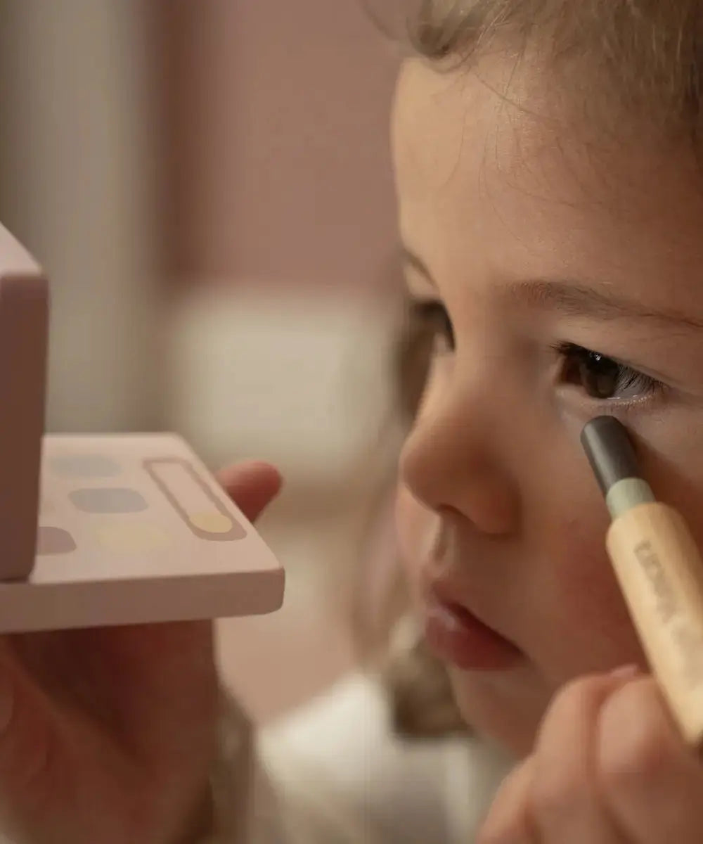 Enfant de 3 ans en train de jouet avec le Set de maquillage en bois de la marque Little Dutch