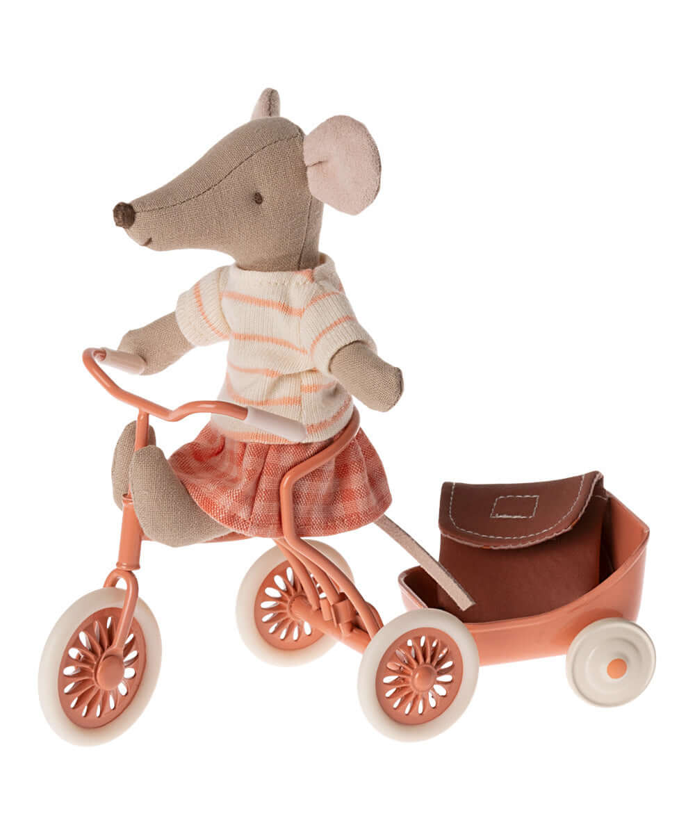 Souris Tricycle Grande Sœur Maileg installée sur un tricycle corail