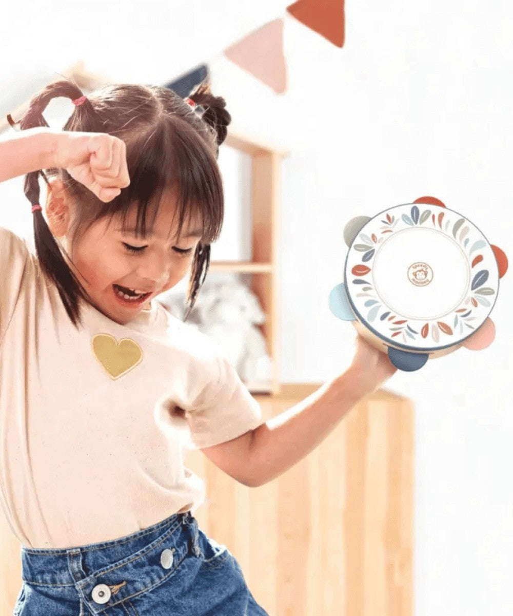 Enfant en train de jouer avec le Tambourin en Bois pour enfant de la marque de jouets Speedy Monkey