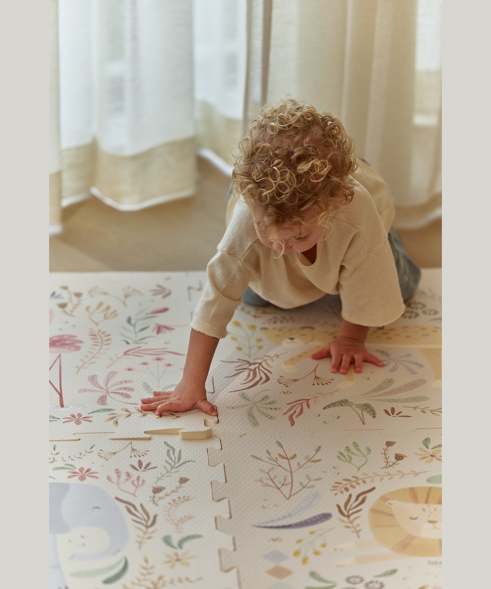 Enfant jouant sur le tapis puzzle Safari Friends Little Dutch dans une chambre