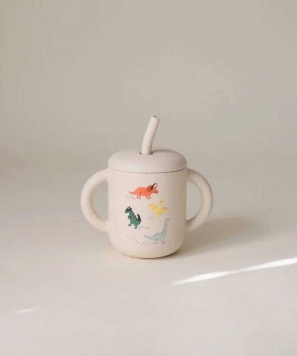 Tasse d'apprentissage à paille en silicone avec motifs dinosaures de la marque Mushie