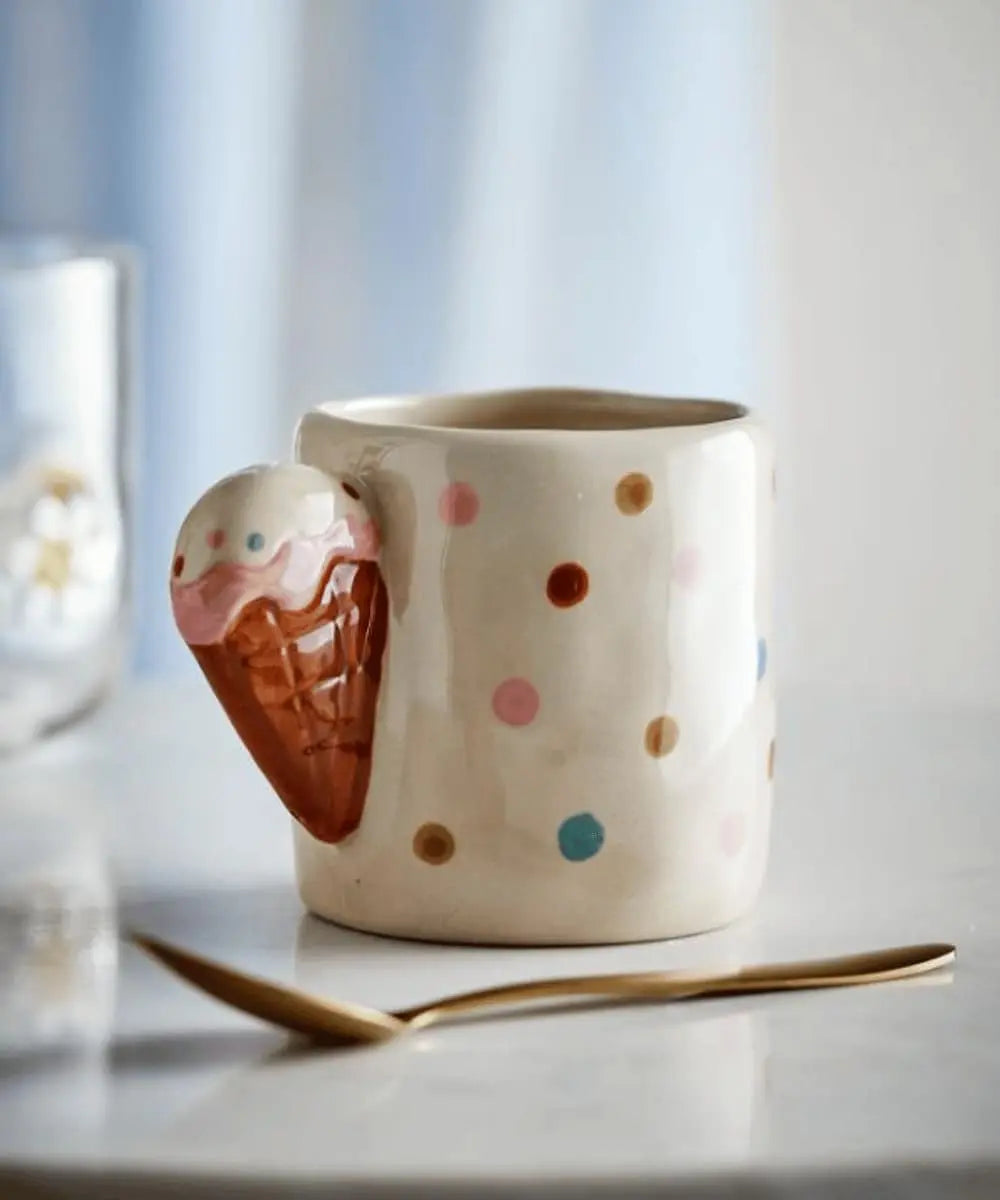 Gros plan sur la anse sculptée façon cornet de glace de la tasse Creamy.