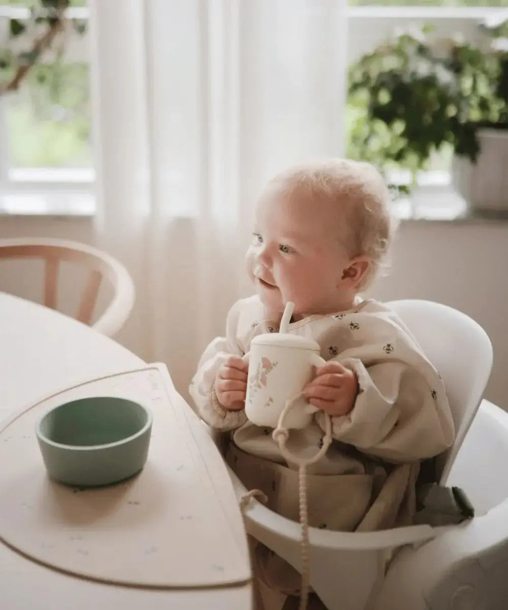 Bébé en train d'utiliser la tasse à paille Pink Flowers de Mushie