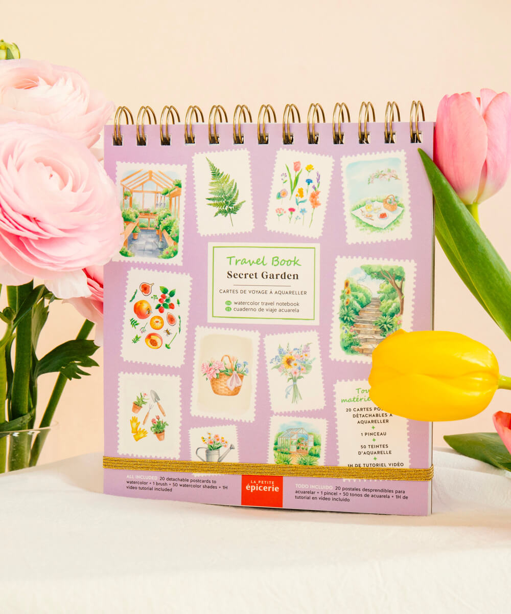 Carnet Travel Book Secret Garden de La Petite Épicerie, présenté avec des roses et des tulipes