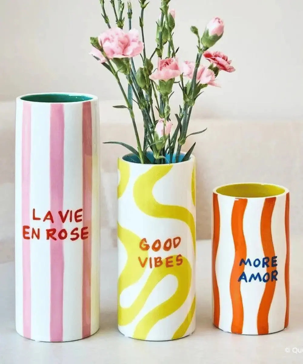 Vase Antonia posé à côté d'autres vases très colorés de Qué Rico