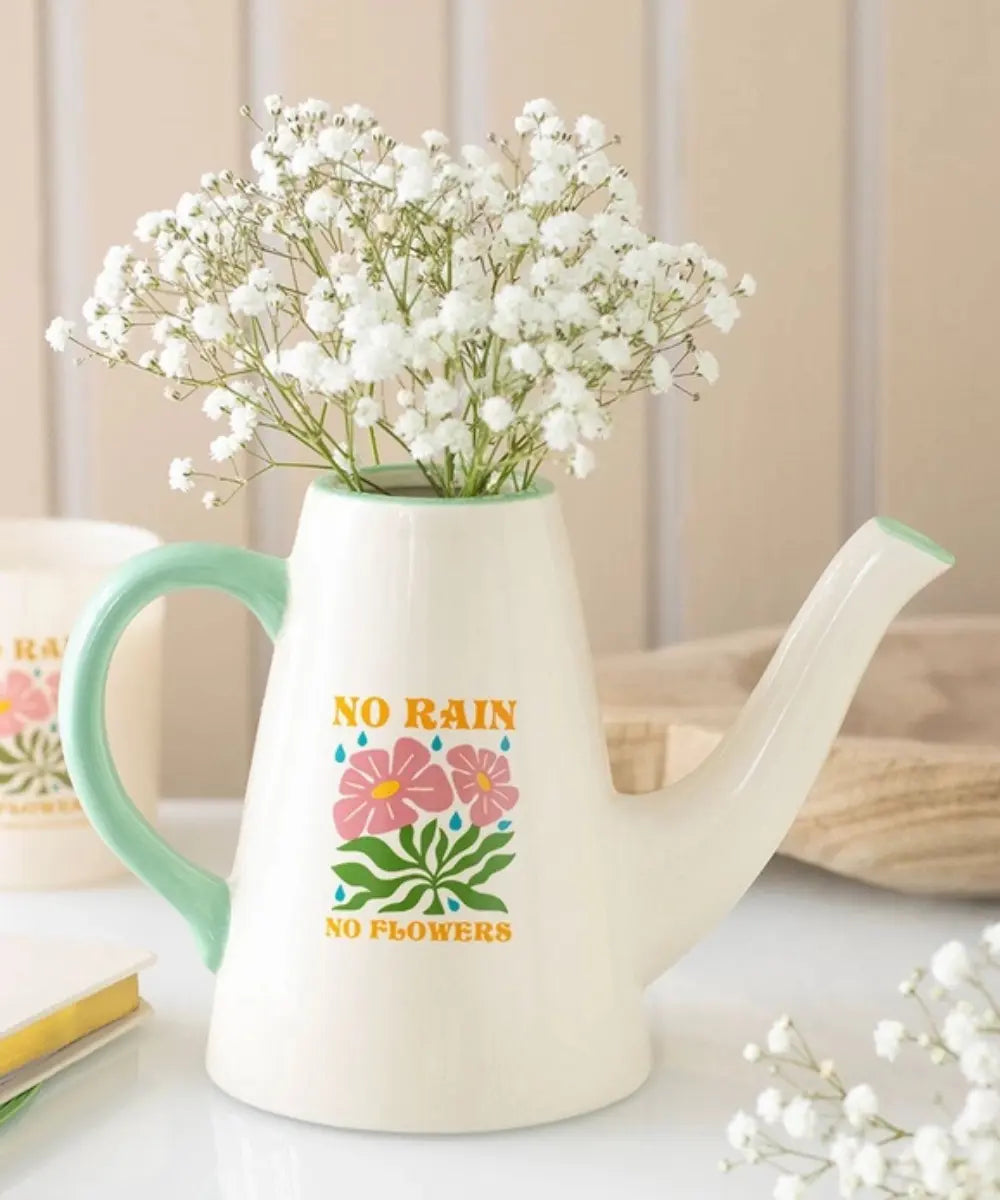 Petit arrosoir en céramique blanc utilisé comme vase déco avec le message No Rain No Flowers.