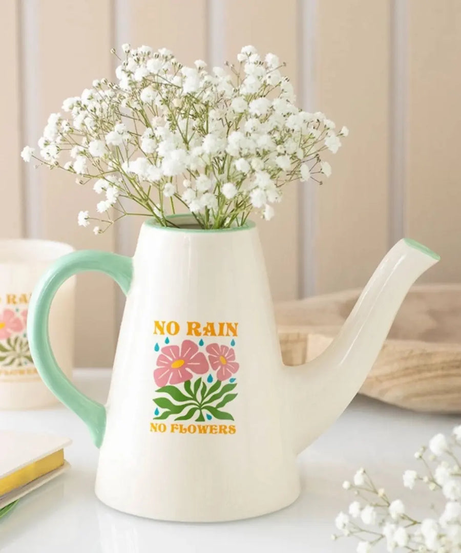 Petit arrosoir en céramique blanc utilisé comme vase déco avec le message No Rain No Flowers.