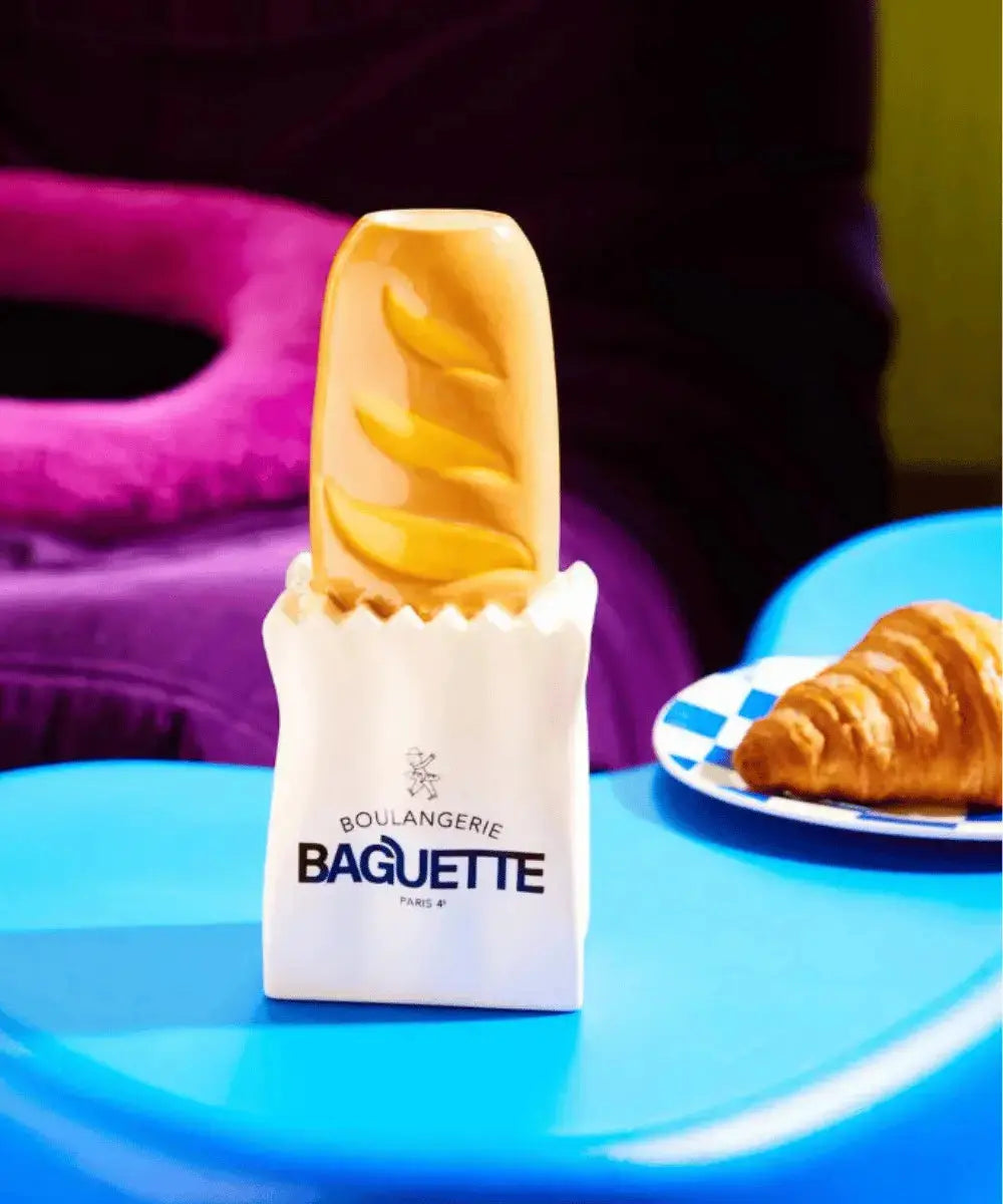 Vase baguette en céramique Fluid Market posé sur une table à côté de viennoiseries