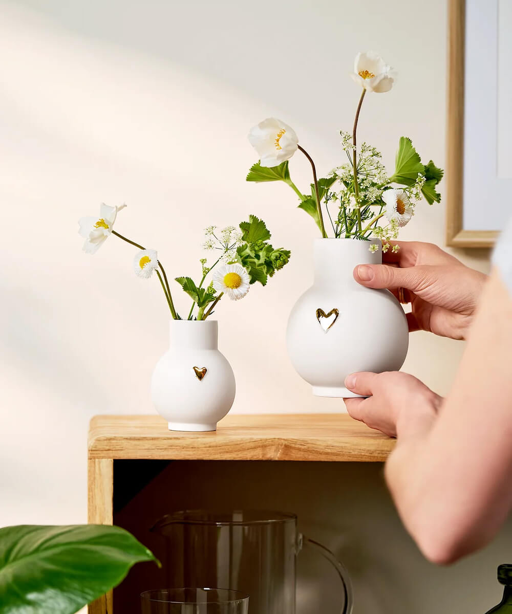Vase boule Cœur doré de Räder tenu dans les mains à côté du mini-vase assorti